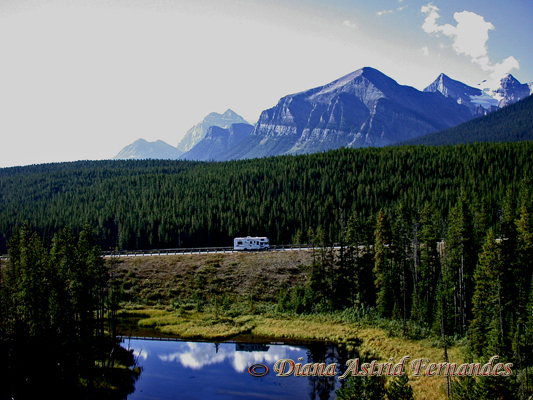 Canada-passing-RV-pine-mountain-and-lake-by-train